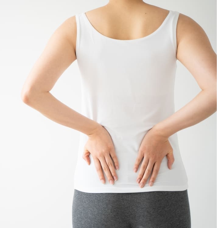 腰を抑える女性